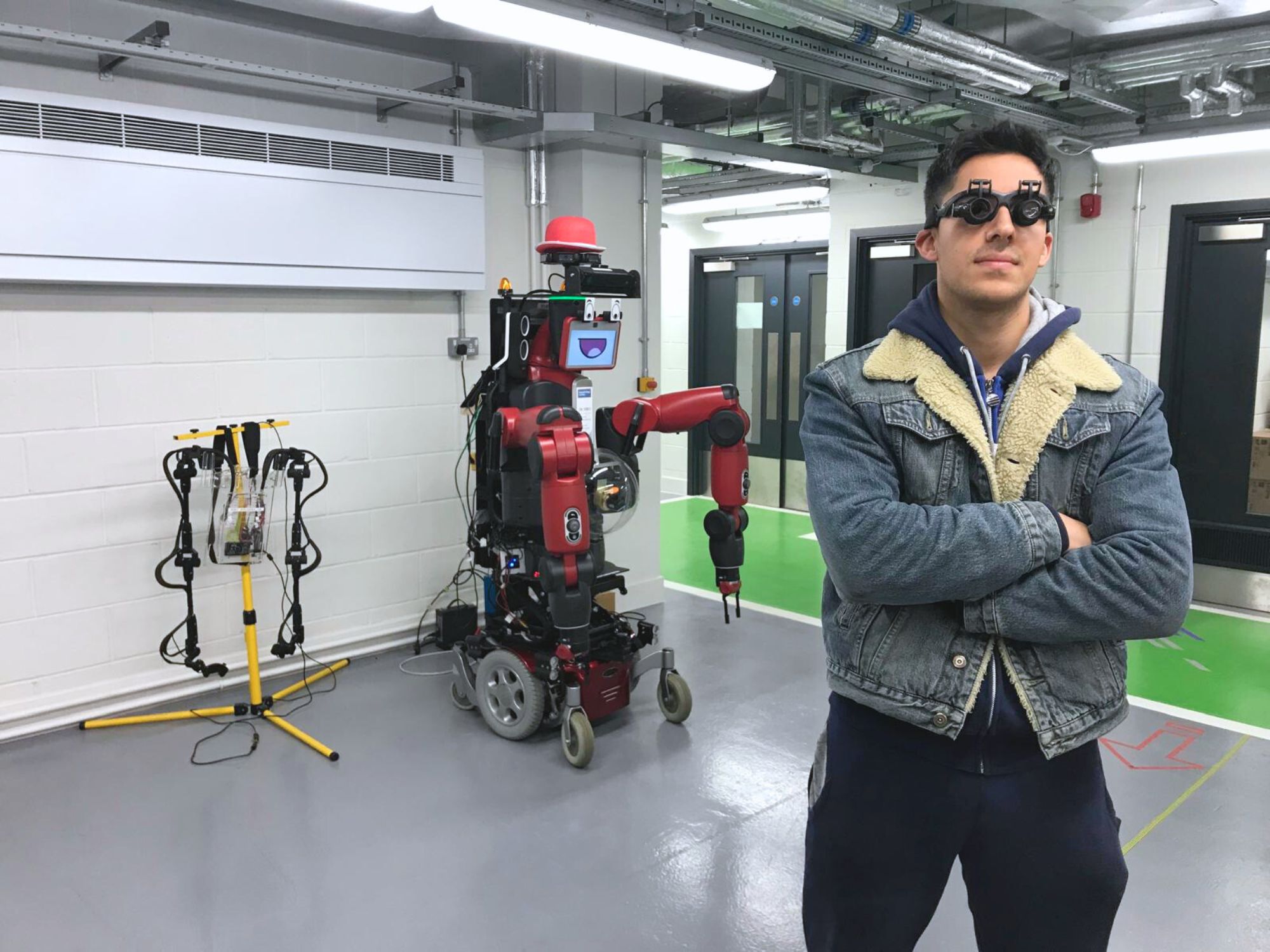 Mory Naimi standing next to Robot DeNiro in the robotics lab at Imperial College London.