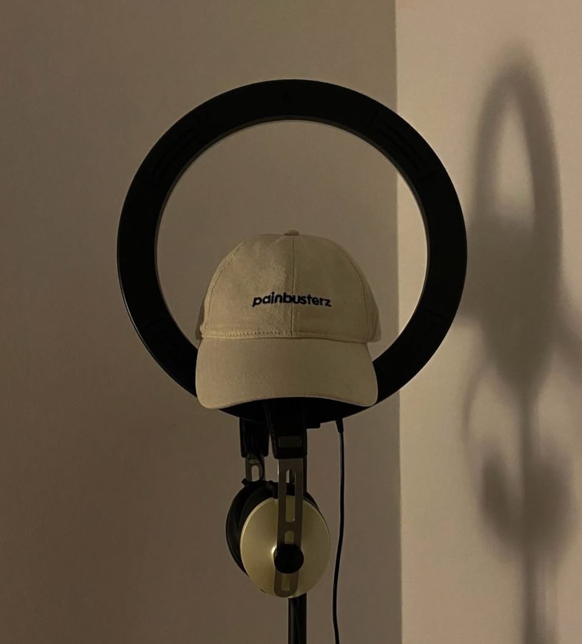 Painbusterz branded hat and headphones hanging together.